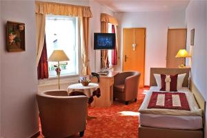 een hotelkamer met een bed en een bureau bij Altstadthotel "Garni" Grimma in Grimma