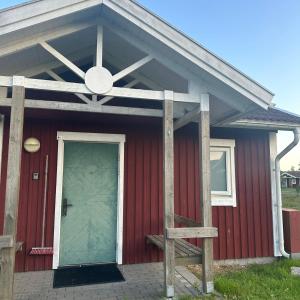 a red house with a green door and a porch at Resort Yxenhaga in Hok +9 photos