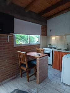 a kitchen with a table and chairs and a stove at MONOAMBIENTES LOS SAUCES in Mina Clavero