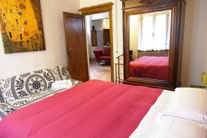 モンテプルチャーノにあるPalazzo Colombiのベッドルーム(ベッド1台、ソファ、鏡付)