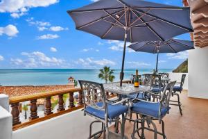 ein Tisch und Stühle auf einem Balkon mit Blick auf das Meer in der Unterkunft Gorgeous Oceanfront Villa With Panoramic Views in Avalon