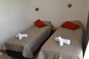 two beds in a room with white towels on them at Departamento Buena Vista in Leones
