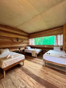 two beds in a room with wooden floors at PuraChata Ecolodge in Iquitos +136 photos