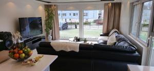 a living room with a black leather couch and a tv at Villa Spa & Haven Stay in Karlskrona