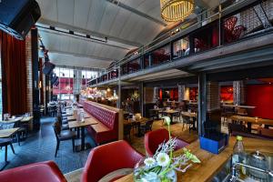 een restaurant met rode stoelen en tafels en een balkon bij Anno in Almere