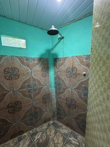 a shower with a glass door in a room at Pousada Araçá Adventure in Sao Pedro