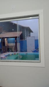 a view of a swimming pool through a window at Horizonte Azul in Cabo Frio