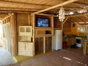 um quarto com uma cozinha e uma televisão numa casa em Kasa Pelikanos em Vichayito