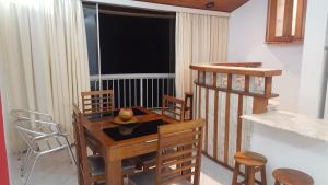 a dining room with a wooden table and chairs at Apartamento Temporada Guarujá Four Seasons in Guarujá