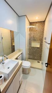 a bathroom with a toilet and a sink and a shower at Lindo Apartamento na Praia de Itapuã - Vila Velha -com ar condicionado na 2 quadra do mar ES in Vila Velha