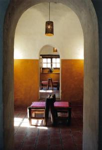 Un arco con una mesa y bancos en una habitación en Refugio Del Pintor en Tilcara