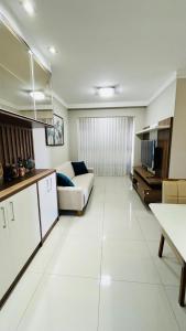 a large white living room with a couch and a tv at Lindo Apartamento na Praia de Itapuã - Vila Velha -com ar condicionado na 2 quadra do mar ES in Vila Velha +30 photos