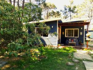 une maison bleue et blanche avec une terrasse couverte dans l'établissement Connection to Nature, à Estación Costa Azul