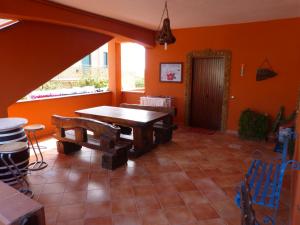 レアルモンテにあるB&B Figli Dei Fioriのオレンジの壁のダイニングルーム(木製テーブル付)