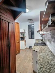 een keuken met houten kasten en een aanrechtblad bij Casita Verde in Rosario