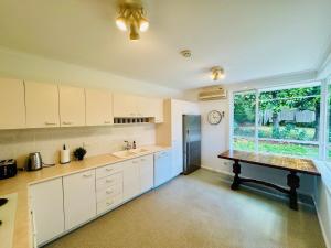a kitchen with white cabinets and a large window at Elegant 4BR Home in Red Hill in Canberra