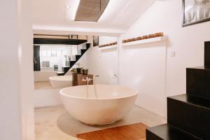 La salle de bains est pourvue d'une grande baignoire et de 2 lavabos. dans l'établissement chic and cozy studio, à Canggu 19 autres photos