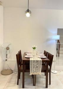 a dining room with a table with chairs and a fan at Cute 2 room House with pool access in Tarlac +6 photos