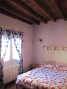 a bedroom with a bed and a window at Casa de piedra en el Valle de Lozoya in Canencia