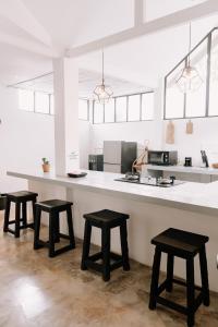 une cuisine avec un comptoir avec quatre tabourets dedans dans l'établissement chic and cozy studio, à Canggu