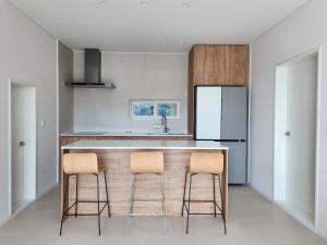 a kitchen with two bar stools and a counter at C'le de monde in Tongyeong