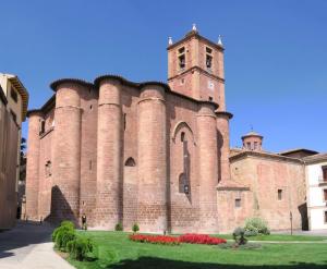 a large brick building with a clock tower on it at Hostal Ciudad de Nájera in Nájera