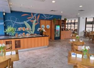 a restaurant with wooden tables and chairs and a mural at Flat em Hotel com Estacionamento Grátis e Piscina in Santos