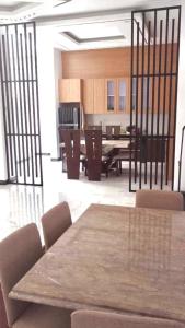 a dining room with a wooden table and chairs at Rumah 5KT Sby Brt dkt Kidzania in Surabaya