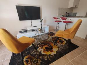 グラハムズタウンにあるThami residence - Self cateringの椅子2脚とテレビのあるリビングルーム