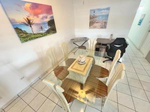 a dining room with a glass table and chairs at Vacation Rental Ceiba PR B16 in Ceiba
