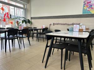 a restaurant with tables and chairs in a room at Xinzhan 23 B&B in Taitung City