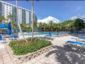 a swimming pool with blue chairs and a resort at Condominium Sunny Isles Ocean Reserve in Sunny Isles Beach