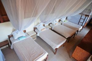 a group of beds in a room with curtains at Besikalung Budget Hostel in Penebel