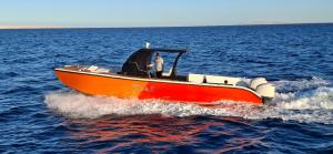 a man on a boat in the water at Tai orange bay Island- Paradis Island- Dolphin - hula hula Island - Magawish island-etc in Hurghada +5 photos