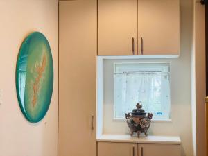 um quarto com uma janela e um vaso numa prateleira em 空港まで車で15分ビーチまで徒歩1分海沿いの閒雲斎 em Itoman