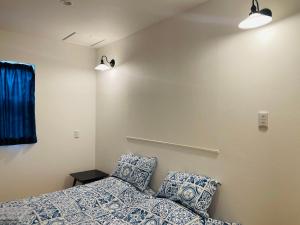 um quarto com uma cama e duas almofadas em 空港まで車で15分ビーチまで徒歩1分海沿いの閒雲斎 em Itoman