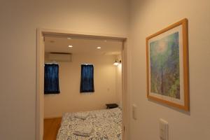um quarto com uma cama e um quadro na parede em 空港まで車で15分ビーチまで徒歩1分海沿いの閒雲斎 em Itoman