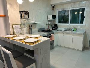 a kitchen with a counter with plates on it at Porto Regina Suite in Cancún