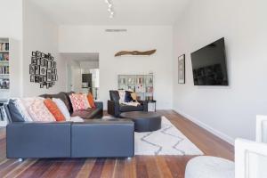 ein Wohnzimmer mit Couch und Flachbildfernseher in der Unterkunft The Cottage at Oak Tree Farm - Vineyards & Wildlife in Hastings