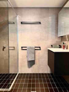 a bathroom with a shower and a sink at Brand new 1 bedroom apartment in Canberra Centre in Canberra