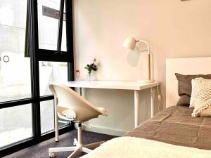 a bedroom with a desk and a chair next to a bed at Brand new 1 bedroom apartment in Canberra Centre in Canberra