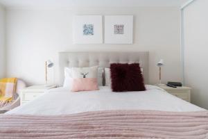ein Schlafzimmer mit einem weißen Bett mit rosa Kissen in der Unterkunft The Cottage at Oak Tree Farm - Vineyards & Wildlife in Hastings