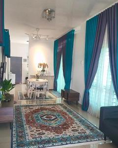 een woonkamer met een tafel en blauwe gordijnen bij Aiman's Rose HomeStay in Teluk Panglima Garang +13 foto's