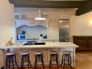 a kitchen with a island with bar stools at Maison du Roy/ Upper Cambers in Saint-Antonin