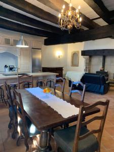 a kitchen and living room with a wooden table and chairs at Maison du Roy/ Upper Cambers in Saint-Antonin