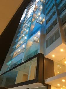 a tall building with glass windows on the side of it at Pórtico tower in Cochabamba