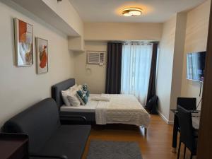 a small room with a bed and a couch at Modern Condo in Ermita Manila near US Embassy and SLMEC in Manila