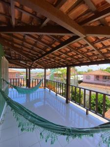 a hammock on the balcony of a house at Casa da Nataliana in Cabo Frio