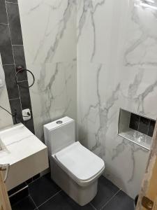 a bathroom with a white toilet and a sink at Moderno & acogedor Apartmento, 2 habitaciones , 4 camas in Concepción de Ataco