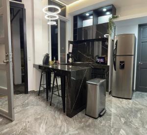 a kitchen with a black counter and a refrigerator at Moderno & acogedor Apartmento, 2 habitaciones , 4 camas in Concepción de Ataco